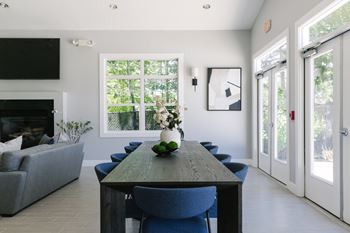 A dining room with a long table and blue chairs.